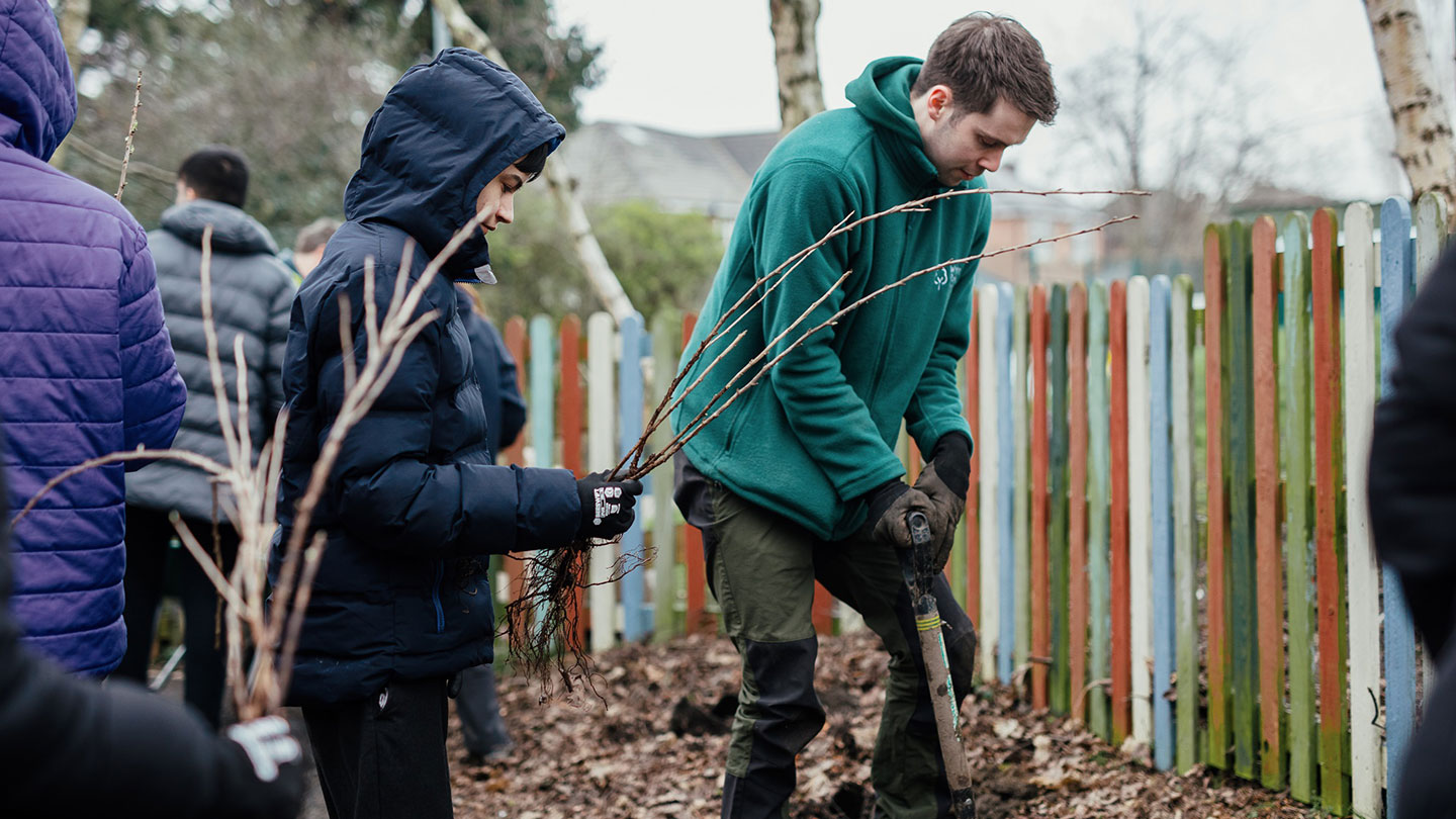 School children planting hedgerow trees.