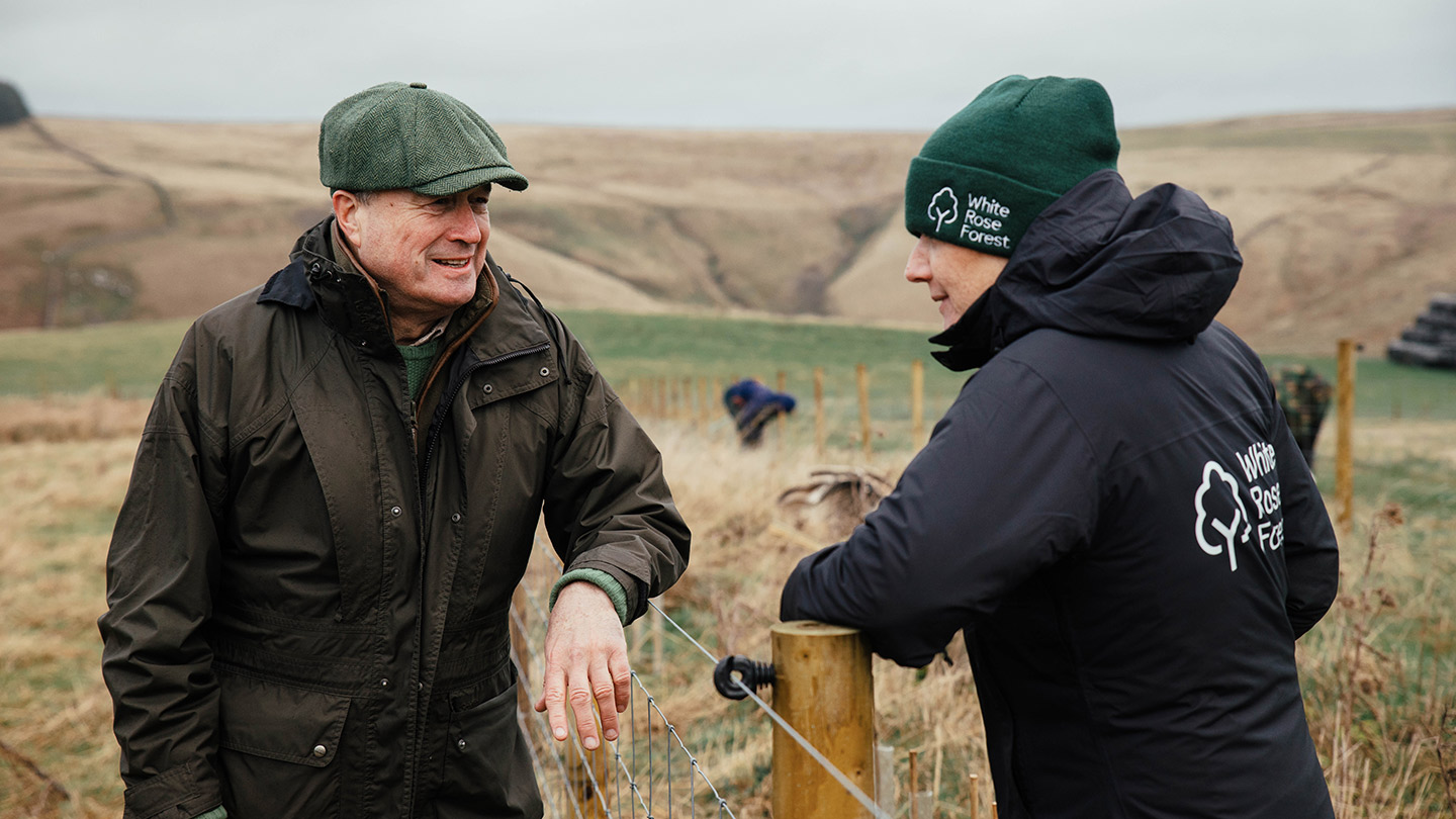Two people talking in upland landscape.